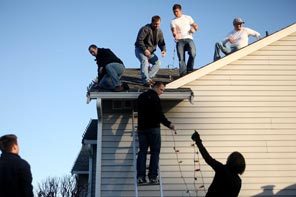 From right, on roof, Graham firefighters Kipp Krattli, Brandon Wetmore, Chris English and Luke Wahl help string Christmas lights with Jeff Davison, on ladder, and others Tuesday at the Richards family home. 