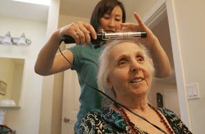 Helen Meader is pleased with the results as caregiver Alta Dorg does her hair at The Gardens at Newcastle, where a recent Wednesday was "beauty day." 