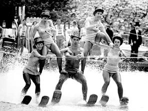Performers in Tommy Bartlett's water-ski show attempt to form a human pyramid while rounding a curve in a specially built water track inside Memorial Stadium.