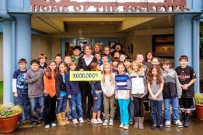 NOW: Holding the sign that was suddenly hung around her neck in 1962, a half-century later the teacher at Issaquah's Sunset Elementary poses with her fifth-grade class.