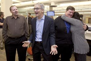 Seattle Times investigations editor James Neff (second from left) celebrates the Pulitzer announcement, along with investigative reporters Ken Armstrong, left, and Michael J. Berens. Reporter Christine Clarridge gives Berens a hug. 