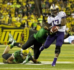 Washington quarterback Keith Price fumbles the ball out of bounds after getting hit yet again by Oregon's quick and forceful defense. 