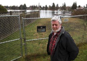 Lee Moyer seen in front of Lake Burien, which is a public lake completely surrounded by private homes. Moyer's efforts to establish a small park at the lake drew a strong negative reaction from homeowners.