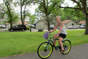 A visitor bikes past lakefront cabins at Sun Lakes Resort, a privately managed part of the state park.