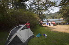  Peg Achterman of Seattle sets up a tent by  Moran’s Cascade Lake, at what she says is one of the best campsites in Washington (at the Southend campground). She and many of the same friends go to the park every year to camp. 