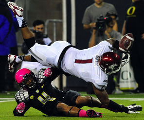 Wide receiver Vince Mayle  fumbles  as he is hit by safety Erick Dargan (4) of  Oregon just in front of the goal line in the second quarter. It was one of the  Cougars’ five turnovers on a night that saw 1,278 yards of total offense.