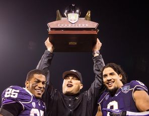 Washington interim head coach Marques Tuiasosopo holds the Fight Hunger Bowl trophy  with offensive and defensive players of the game, Bishop Sankey (25) and Hau'oli Kikaha. <br/>