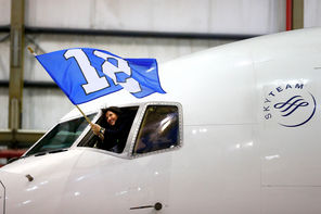 A crew member on a chartered Delta Boeing 767-300 carrying the Seattle Seahawks waves the 12th Man flag as the jet heads   into a hangar Sunday evening at Newark Liberty International Airport, the first stop in a long week of activities before next Sunday’s Super Bowl.