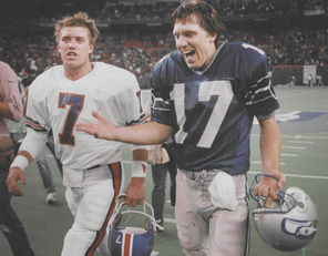 “We won our first playoff game against Denver and hopefully the first Super Bowl win is against the Broncos,” said Dave Krieg, right, with John Elway.