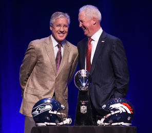Seahawks coach Pete Carroll, left, and Denver coach John Fox share the stage with the Lombardi Trophy on Friday.