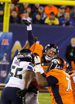 Broncos quarterback Peyton Manning is hit by Seahawks defensive end Cliff Avril as Manning is intercepted by Seahawks linebacker Malcolm Smith, who returned the ball 69 yards for a touchdown.
