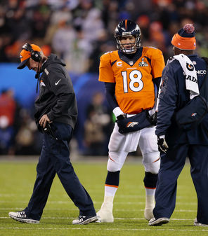 Broncos coach John Fox, left, walks off after talking to Denver quarterback Peyton Manning as the Broncos were totally frustrated in getting anything going offensively in the first half.