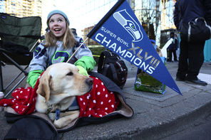 Kaitlyn Steffy, 10, of Woodinville, Wash., sits with the family dog Tina waiting for the Super Bowl champions parade to begin Wednesday.