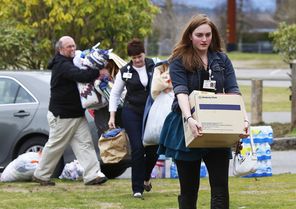  Claire Logan, at right, carries supplies to help set up an evacuation center at Post Middle School in Arlington to assist those impacted by the landslide on the North Fork of the Stillaguamish river.