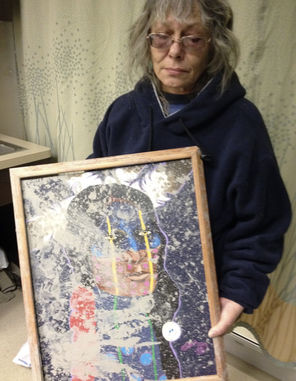 Slide survivor Robin Youngblood with a muddy picture from her destroyed home. 