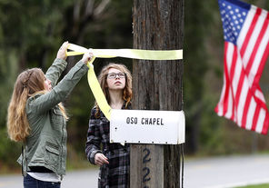 Randi Ray, left, daughter of Oso Community Chapel’s Pastor Gary Ray, and his daughter-in-law Molly Ray, right, put up yellow ribbons around the chapel grounds on Sunday before the 10 a.m. service. “We may be knocked down  but we're not knocked out,” Pastor Ray said in his sermon.