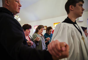 At Saint John Mary Vianney Catholic Church on Sunday, from left, Terry Haldeman, DeLayne Haldeman, Samantha Valencia, Breanna Valencia, J.J. Haldeman and Tyler Haldeman  hold hands and pray for the valley and the communities affected by the mudslide.