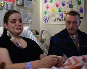Oso mudslide survivor Amanda Skorjanc, 25, talks to the media while sitting in her hospital bed with her partner, Ty Suddarth, at her side Wednesday in Seattle. She was trapped in her home with her 5-month-old son, Duke Suddarth.