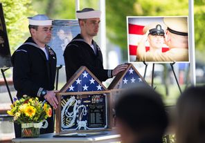  HT1 Jeff Hanke and HT2 Antonty Marino display the shadow boxes that Marino built for Cmdr. L. John Regelbrugge III and NCC Billy L. Spillers, who died in the March 22 Oso mudslide, during a memorial service at Naval Station Everett on Friday.