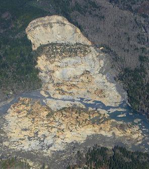 John Reed’s house is seen near the bottom left of this aerial photo, taken two days after the March 22 mudslide. Reed spent several harrowing nights in his house listening to the earsplitting noise of trees and debris crashing in the river.