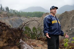 John Reed stands underneath the face of the mudslide, on the  bank of the North Fork Stillaguamish River. 