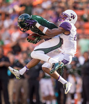 Hawaii's Marcus Kemp pulls down a tipped pass, defended by Washington's Marcus Peters. The reception got Hawaii into the red zone from where they would score a field goal in the first quarter. 