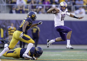 Washington quarterback Cyler Miles eludes a tackler during a 1-yard run in the fourth quarter. Miles threw for 273 yards and three touchdowns.