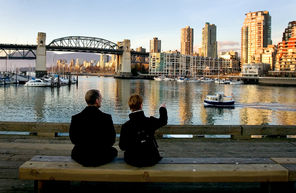 A couple enjoys the view from   Granville Island of downtown Vancouver, B.C. The little island entices visitors with its bustling public market and dozens of  restaurants and local artisans’ shops. 
